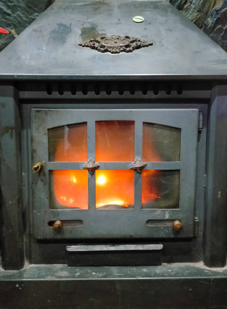 istock fireplace with iron door and lit glass window 2200195558