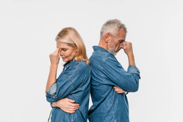 istock Problems in marriage, difficulties in relationships concept. Upset unhappy elderly married couple have quarrel, standing apart with arms crossed on chest, don't talk to each other, white background 2200195571
