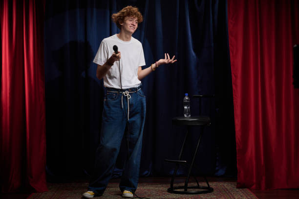 istock Comedian Performing on Stage with Microphone in Hand 2200195965