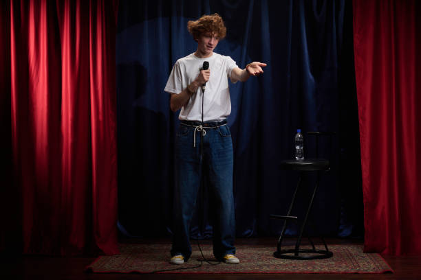 istock Young Comedian Performing Stand-Up Comedy on Stage 2200195970
