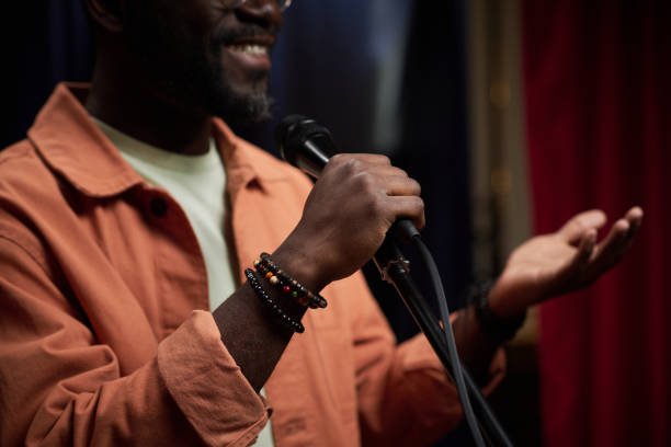 istock Smiling Black Person Speaking into Microphone 2200195992