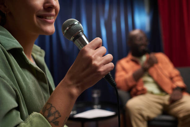 istock Smiling Woman Holding Microphone During Discussion Event 2200196044