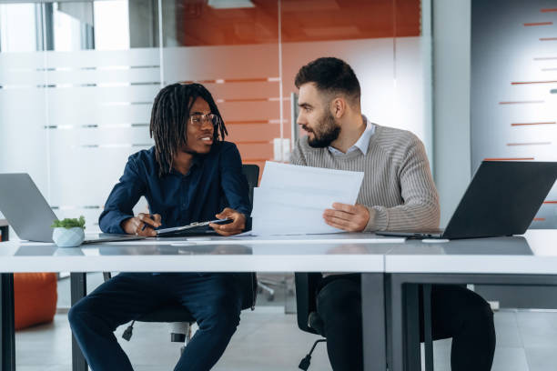 istock Some paperwork. Two men are in the office 2200197340