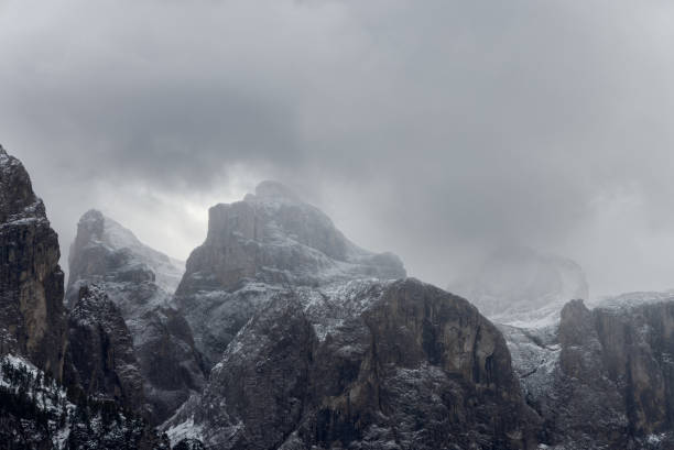 istock Snow covered cliffs of the Dolomites under a dense overcast sky, with rugged rock formations and shadowed crevices creating a dramatic, cold alpine atmosphere 2200197393