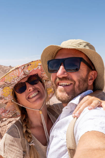 istock Smiling Couple Taking a Selfie on a Sunny Desert Adventure 2200197941