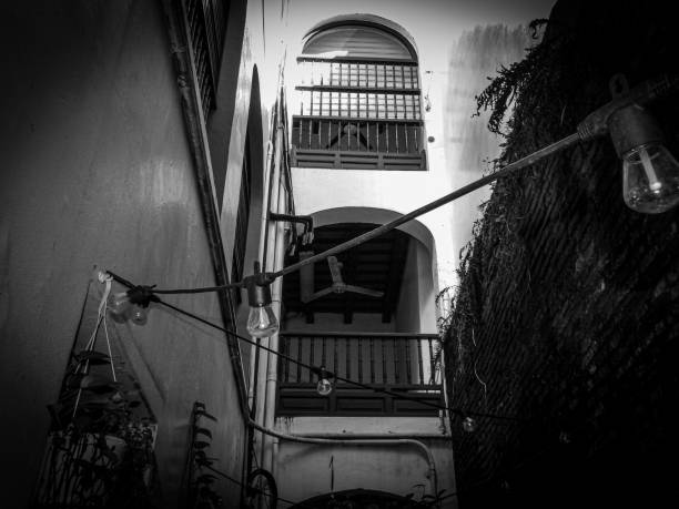Old building in San Juan, Puerto Rico. It has plants and is decorated with modern light bulbs. There is also a ceiling fan in the background.
