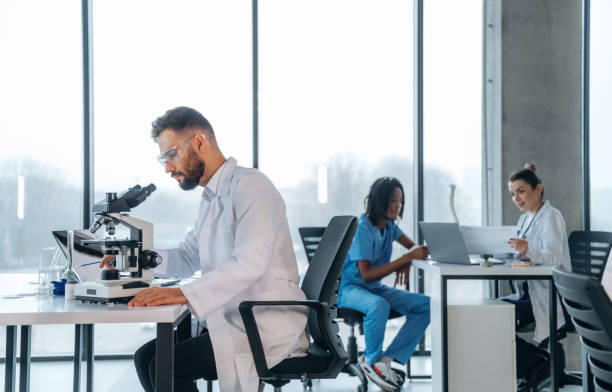 istock In lab coat, sitting with microscope. Doctors are in the clinic 2200200259