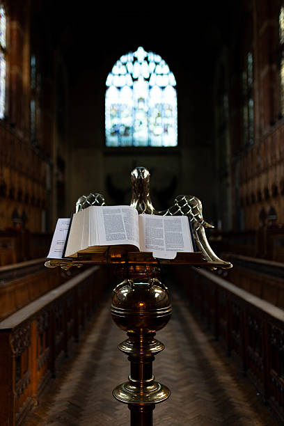 istock Open book on a lectern with stained glass windows in a historic chapel during daylight 2200202298