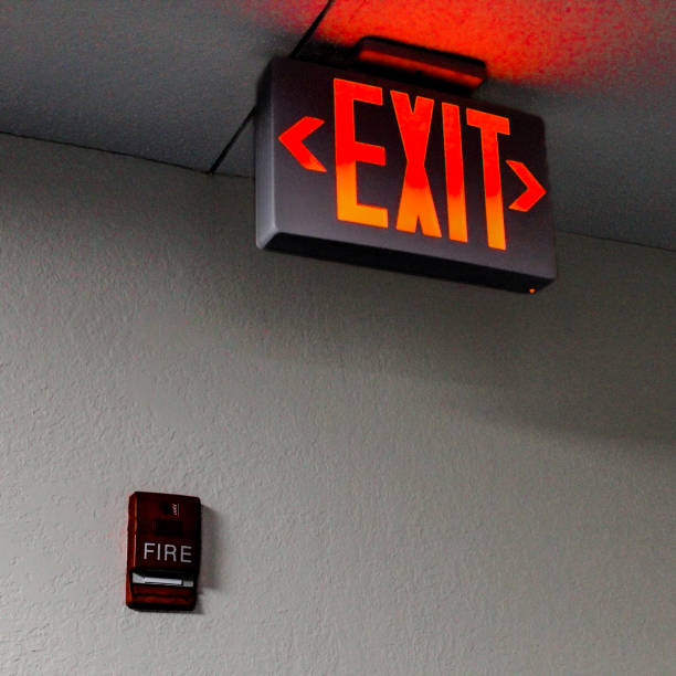 istock close-up of a large illuminated LED emergency exit sign and fire alarm safety pull 2200204085