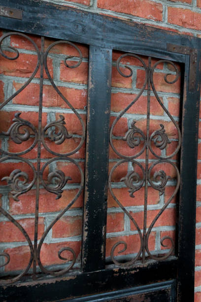 istock close-up of iron insert with scroll design on reclaimed painted door against brick wall background 2200204690