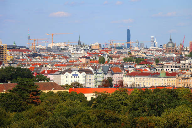 vienna city, capital of austria, with skyscrapers and many bridges over the danube river on sunny autumn day with clear blue sky and autumn colored trees
