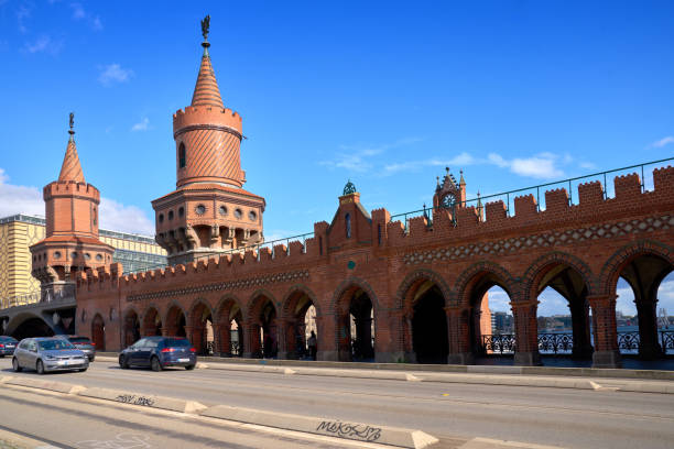 Crossing the historic Oberbaum Bridge, over the Spree river, on a scooter. Berlin, Germany. September 28, 2024.