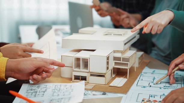 istock Collaborative Design Meeting with Architectural Model and Blueprints on a Table in Modern Office Environment SACTR 2200207131