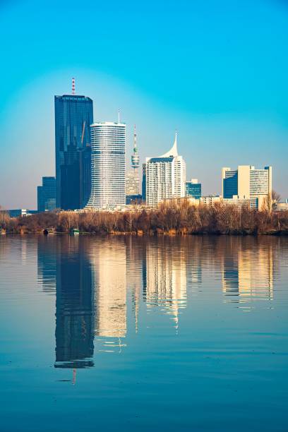 high rise buildings on the edge of the river Danube in Vienna with reflection
