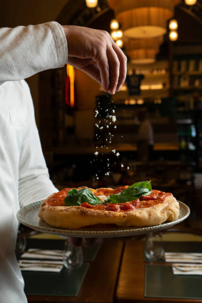 Sprinkle cheese on a fried Montana pizza with cheese and basil