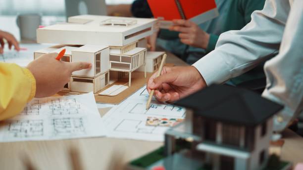istock Detailed Model Building Discussion in Architecture Studio with Sketches, Plans, and Models in Focus for Creative Design Development SACTR 2200208233