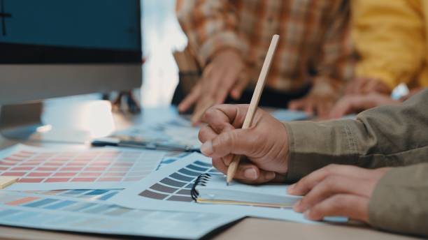 istock Hands Engaged in Color Selection and Design Planning at a Creative Workspace with Color Swatches and Digital Monitor in Focus SACTR 2200208474