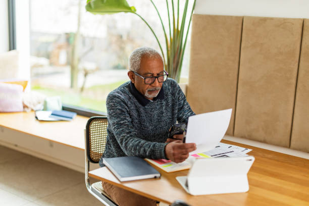 istock Senior Man Managing Finances At Home 2200209419