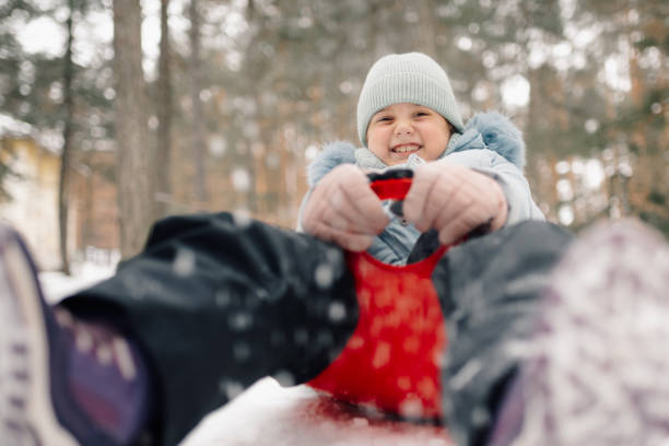 cheerful happy couple with a sledge in the winter forest, happiness in winter nature