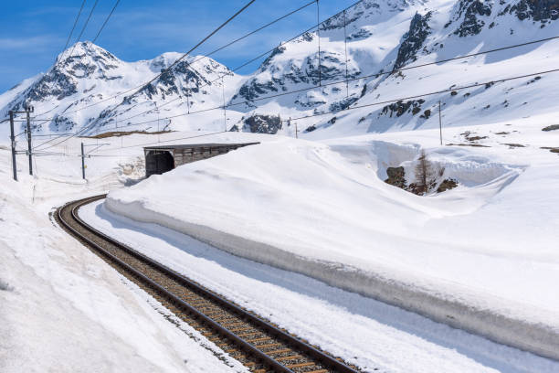 istock Empty railway track leading to a tunnel in a snow covered mountain scenery 2200212731