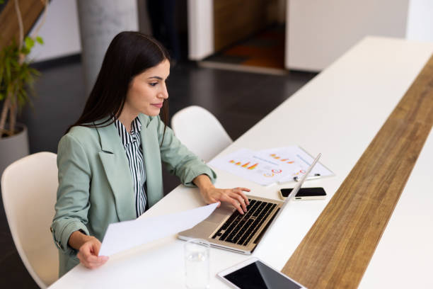 istock Confident Latina professional handling tasks on a laptop in a stylish office 2200215918
