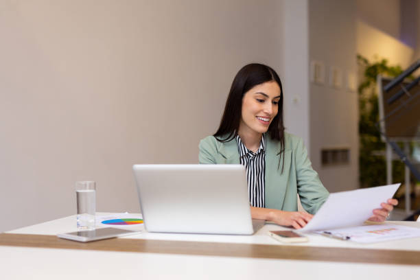 istock Dedicated Latina professional reviewing documents while working on a laptop 2200216866