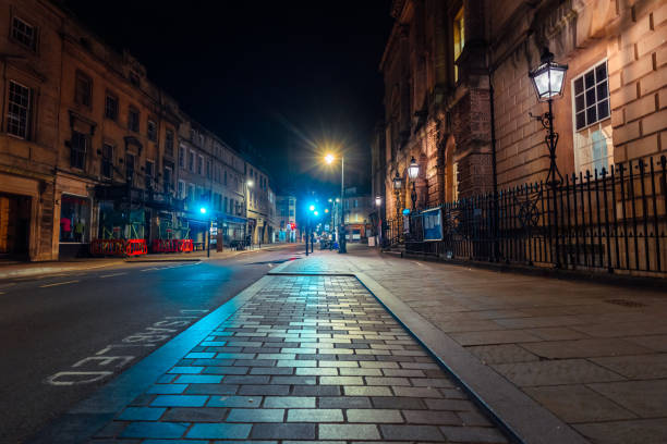 istock Empty street in bath, england at night illuminating disabled parking sign 2200217119