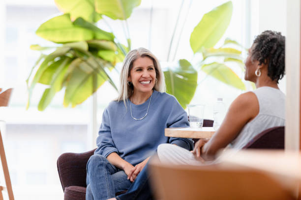 istock Two Women Enjoying a Conversation and Coffee in a Bright Cafe 2200217316