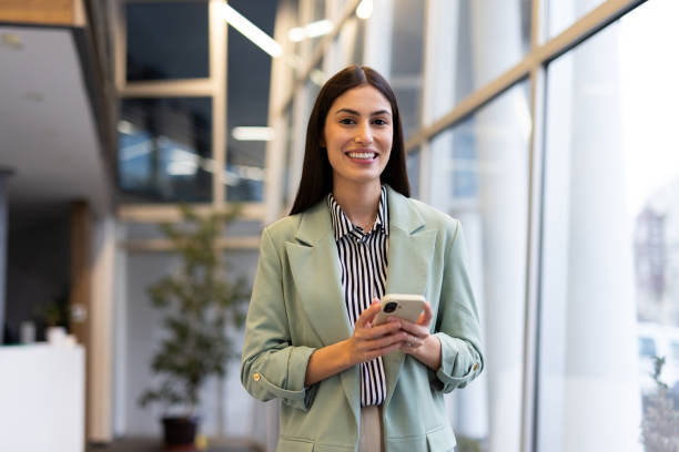 istock Dedicated Latina entrepreneur using a smartphone for work in a corporate space 2200217373