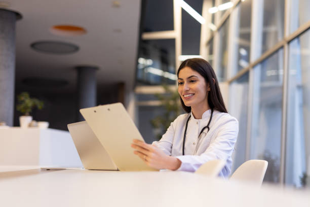 Dedicated Latina physician typing on a laptop at her desk