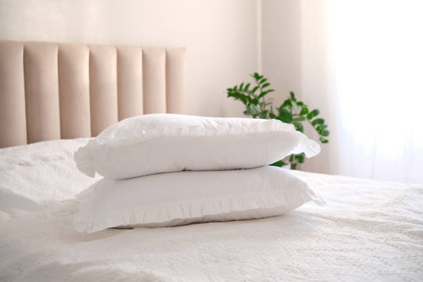 istock Two white pillows on bed morning light on pillows. 2200218910