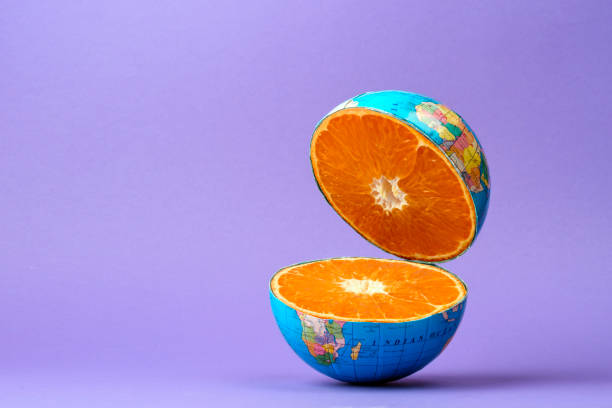 istock Surreal composition of a sliced globe revealing juicy orange pulp inside, floating against a purple background. Concept of global freshness and nature. 2200219288