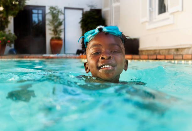 istock Happy African boy swimming in pool and having fun 2200220022