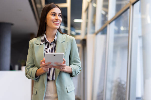 istock Young Latina CEO using a tablet to review financial data in an office 2200220875