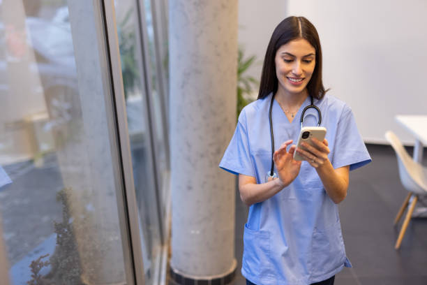 istock Efficient Latina nurse checking schedules on a smartphone 2200221037