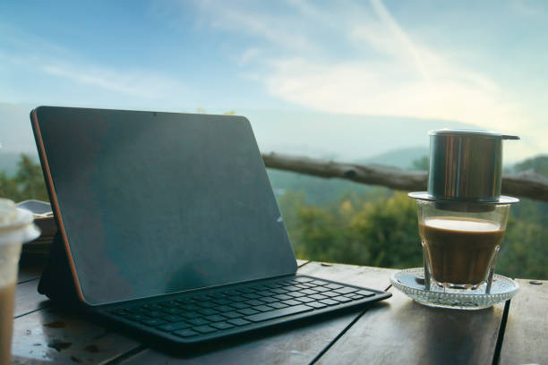 istock Modern Workspace Outdoors with Tablet and Vietnamese Coffee at Sunrise 2200221620