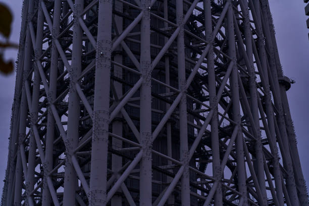 This is a low-angle photo of a tower rising into the sky at dusk. The gradation of the sky and the silhouette of the tower are impressive, creating an urban yet mysterious atmosphere. It can be used as stock photos of buildings, cityscapes, sunsets, landmarks, etc.