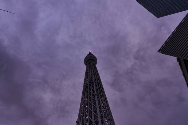 This is a low-angle photo of a tower rising into the sky at dusk. The gradation of the sky and the silhouette of the tower are impressive, creating an urban yet mysterious atmosphere. It can be used as stock photos of buildings, cityscapes, sunsets, landmarks, etc.