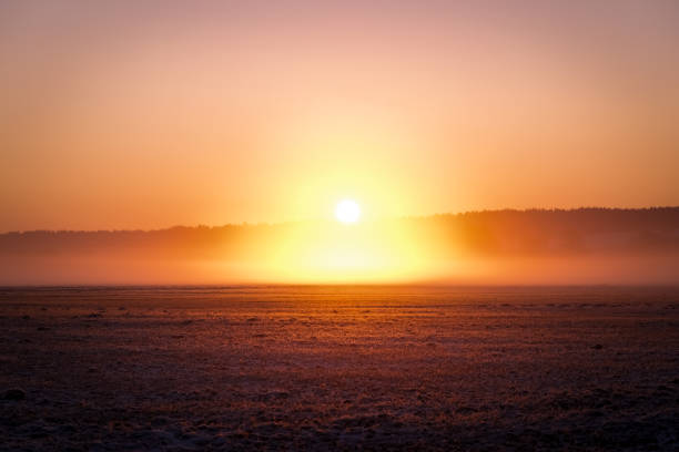 Winter sunset over a frozen snowy landscape on Senja island in Northern Norway at the end of a beautiful winter day in the arctic circle.