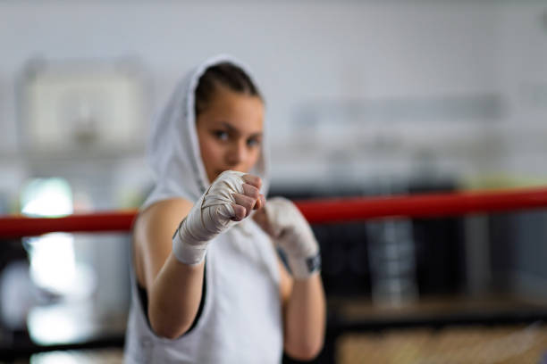 Fit female boxer training with her male coach