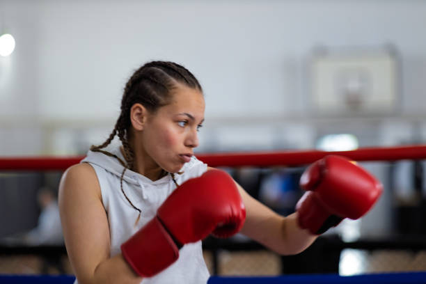 istock Fit young female boxer training with her male coach 2200224531