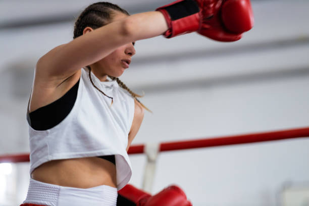 istock Fit young female boxer training with her male coach 2200224535