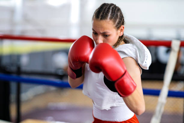 istock Fit young female boxer training with her male coach 2200224536