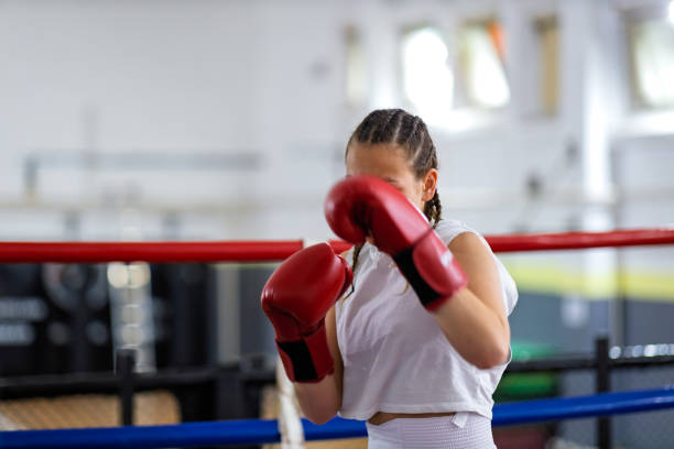 istock Fit young female boxer training with her male coach 2200224578