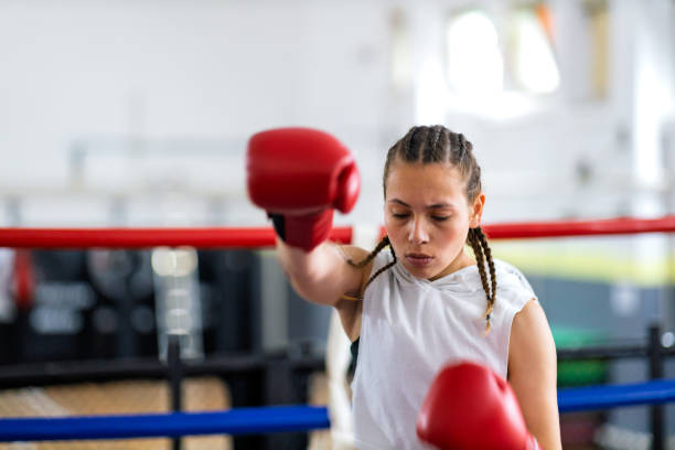 istock Fit young female boxer training with her male coach 2200224585
