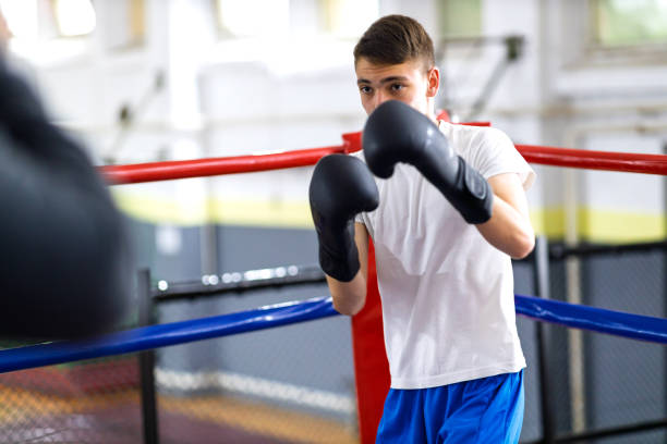 istock Young boxer training with her male coach 2200224777