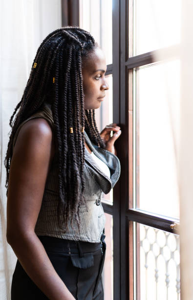 istock Woman looking out the window 2200226155