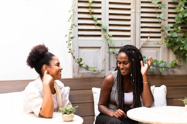 Women talking and smiling at outdoor cafe