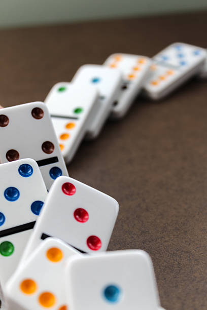 dominoes in the process of falling down isolated on a background. concept for cause and effect, fate, causality, fallen, chain reaction, predictability business backdrop
