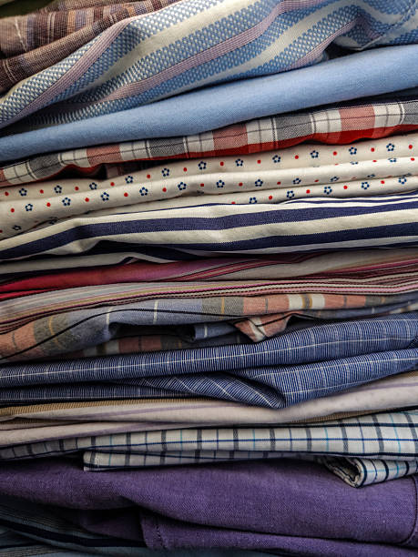 istock close-up of a stack of neatly folded clothing textiles mens button down shirts. 2200227258